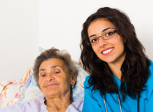 caregiver with elder patient smiling